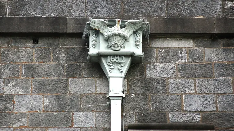 Dachrinne mit Fallrohr und Ablauf an einer Hausecke